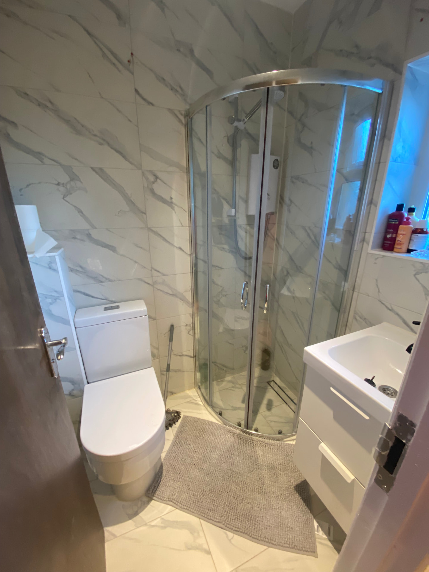 Marble-tiled en-suite shower room